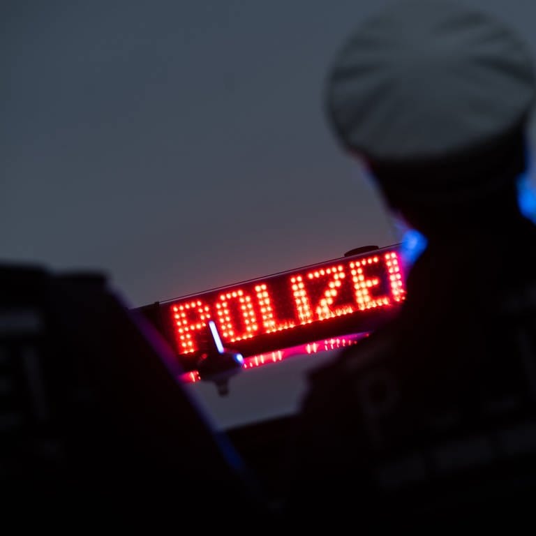 Zwei Polizisten stehen vor einem Polizeifahrzeug. (Foto: dpa Bildfunk, picture alliance/dpa | Marijan Murat (Symbolbild))